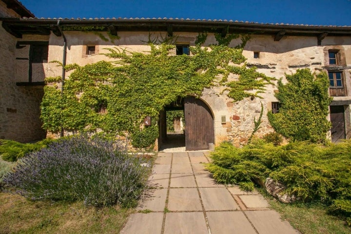 Entrada de la posada rodeada de naturaleza.