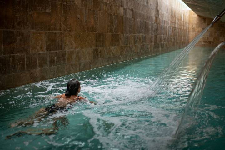 Una mujer nada en la piscina climatizada del spa del Parador de El Saler.