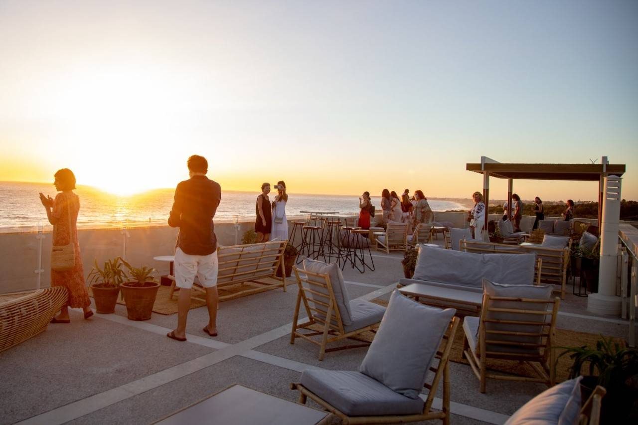 clientes dsifrutan de la puesta de sol  en la terraza superior  de el Cuartel del Mar