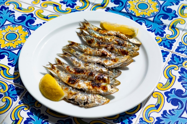 Sardines espeto, Malaga style fish on stick barbecue prepared on olive tree firewoods on beach