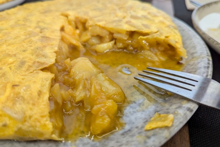 Betanzos omelette with juicy egg on a plate with a fork, A Coru�a municipality, Galicia, Spain