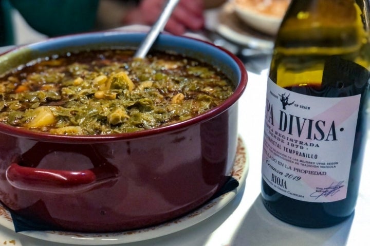 Puchero y una botella de vino en 'El Llar de la Catedral'. Foto: Facebook 'El Llar de la Catedral'