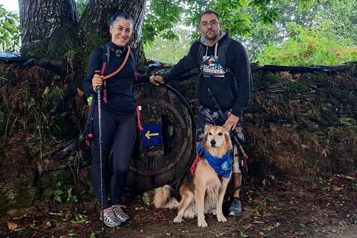 Peregrinos del Camino de Santiago junto a su perro.