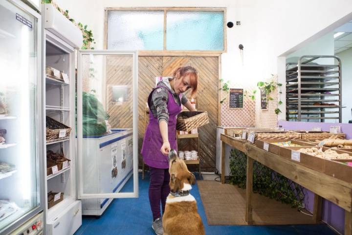 Tienda obrador 'Miguitas' (Madrid): dependienta dándole una galleta a un perro