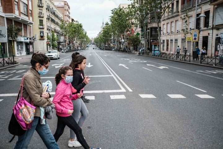 Personas cruzando un paso de peatones en Bravo Murillo el primer día de salida con niños permitida.