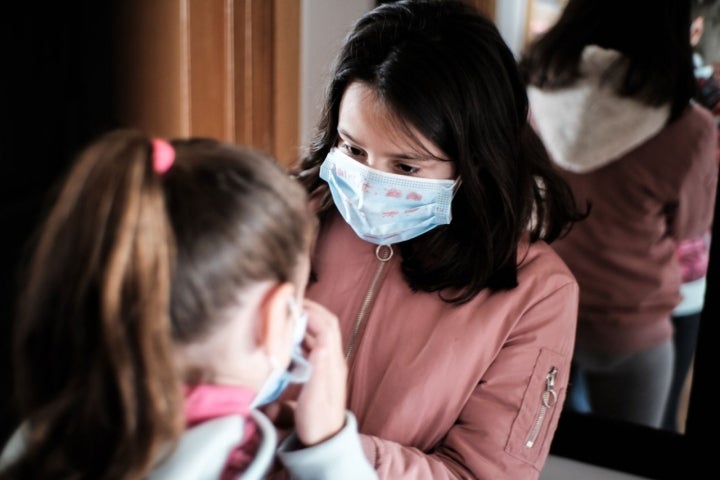 Dos niñas se colocan las mascarillas antes de salir a la calle en Madrid.