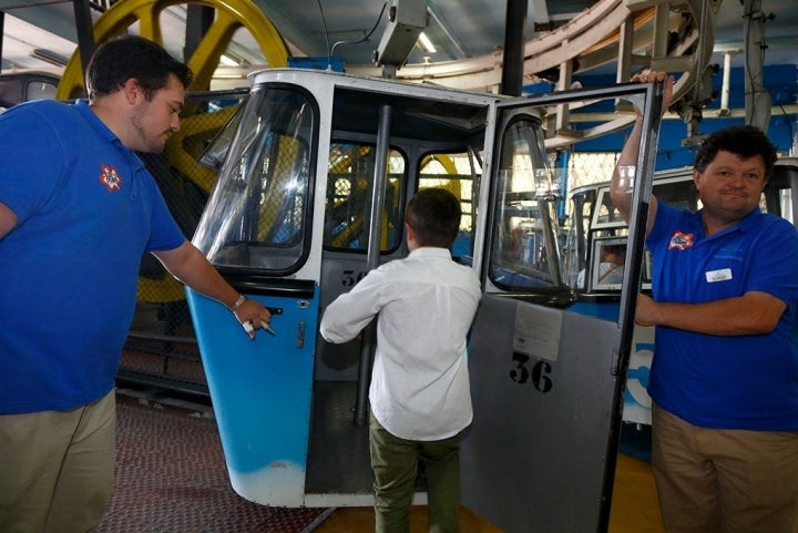 Pepe sube a la cabina del Teleférico mientras el encargado le sujeta la puerta.