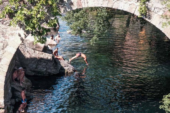 La gente se lanza al agua desde el puente de la garganta de Cuartos en el Losar de la Vera