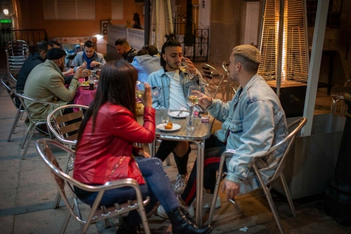 Tres jóvenes en la terraza de la 'Taberna La Trastienda' en Ceuta.