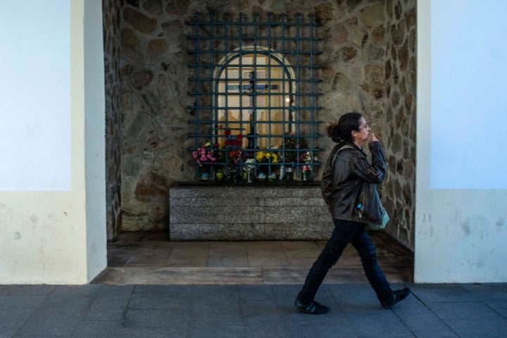 Una mujer se persigna ante el Cristo