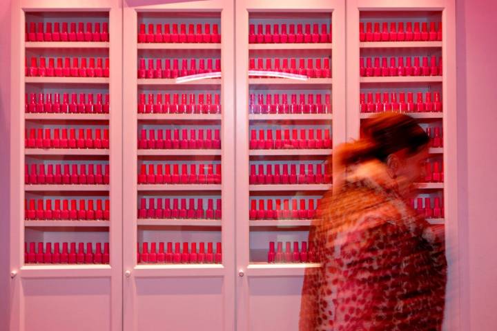 El vestíbulo está repleto de botes de esmalte de uñas bañados en una luz rosa, para deleite de los clientes.