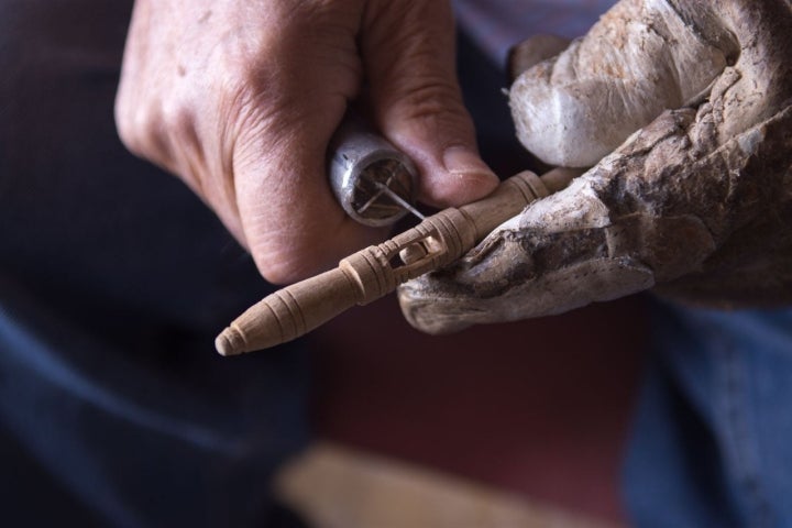 Francisco talla a mano un bolillo de olivo.