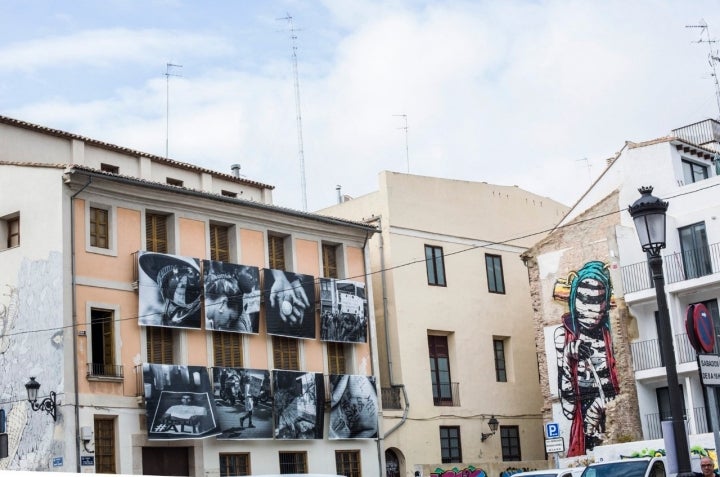 Las fotos en blanco y negro colgadas en los balcones combinan con la fachada intervenida.