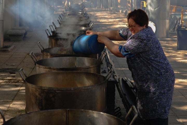 Echando los ingredientes a las 25 ollas de cocido de vaca para la celebración del Santo Voto, Ciudad Real.