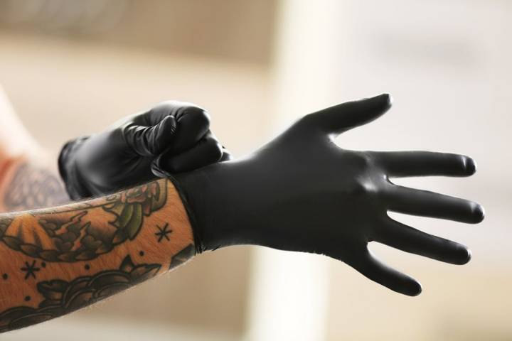 Los guantes negros siempre han sido muy utilizados por los profesionales del tatuaje. Foto: Shutterstock.