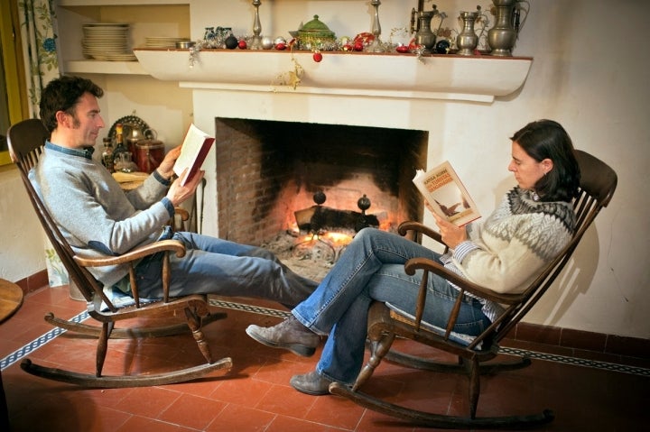 Pareja leyendo junto a la chimenea