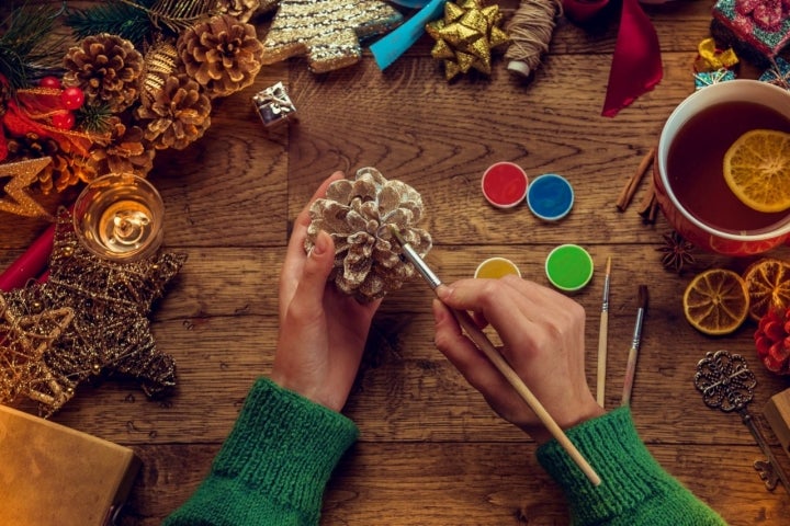 Pintando de colores piñas para la decoración de Navidad.