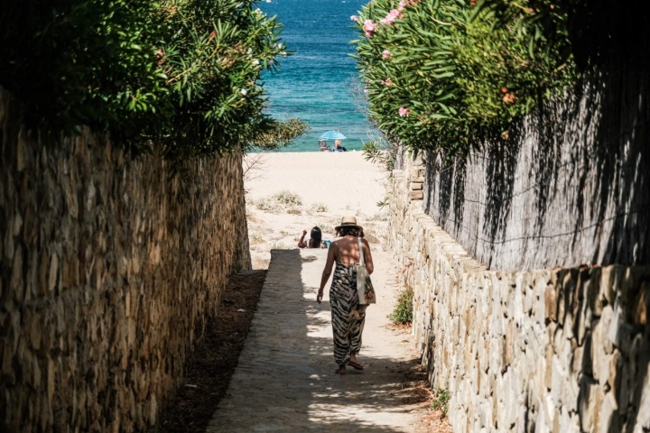 Una mujer bajando por las escaleras que dan acceso a la Playa de los Alemanes.