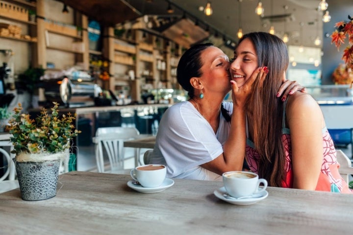 Madre e hija tomando un café.