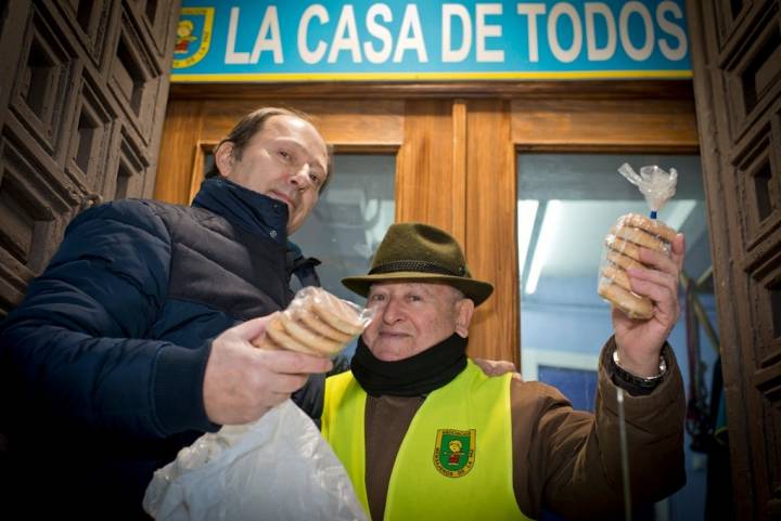 El buen humor impregna también a estos dos voluntarios que venden los panecillos fuera de la iglesia.