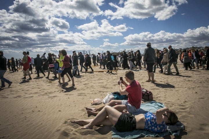 Los turistas no pueden evitar sacar el móvil para intentar capturar el fervor popular.