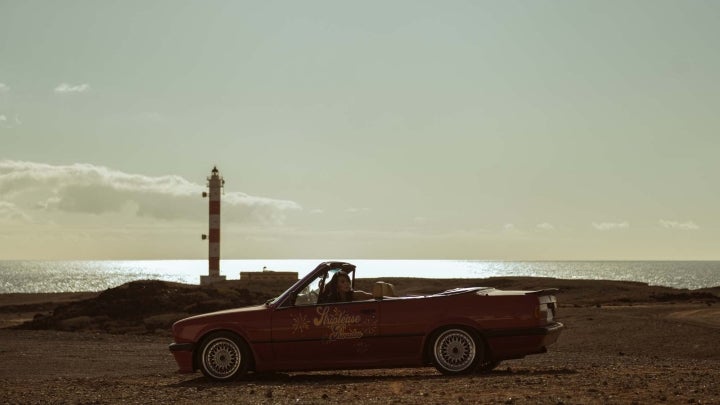 Coche rojo aparcado junto a un faro de la isla de Tenerife