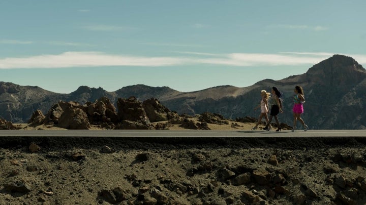 Tres chicas caminan por una carretera