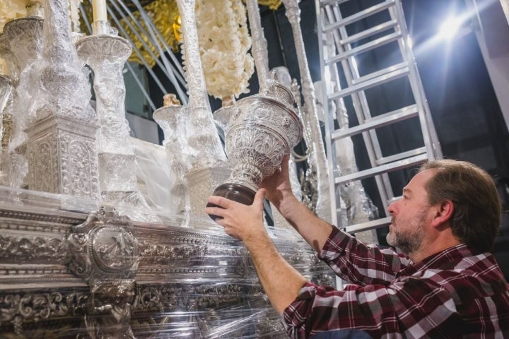 Uno de los priostes de la Hermandad de la Sed da lustre a la plata de la Virgen de Consolación.