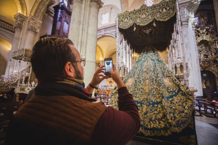 Los curiosos se acercan a las iglesias estos días para ver los pasos montados como este palio de la Virgen de la Merced.