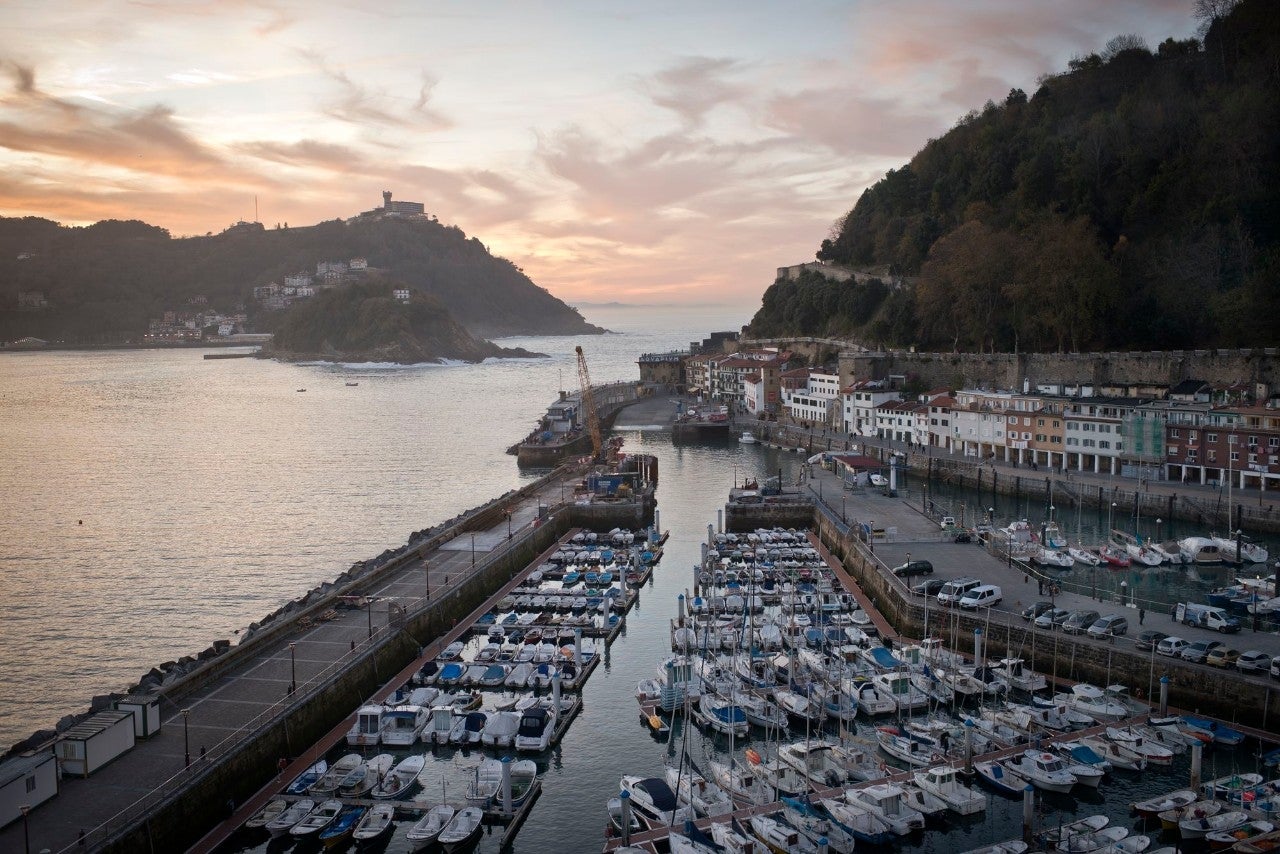 Vista desde una habitación, de la bocana de la entrada del mar en La Concha, con el puerto y sus casas marineras de colores.