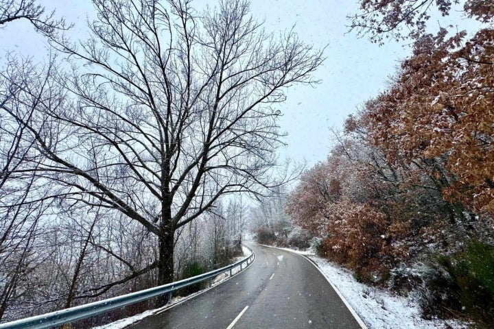 Carretera nevada que bordea el pantano de Barrios de Luna