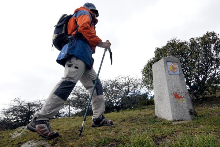 Camino de Santiago Madrileño. Un peregrino pasa ante un mojón de la Comunidad de Madrid, en el pie de sierra. Foto: © Marga Estebaranz 