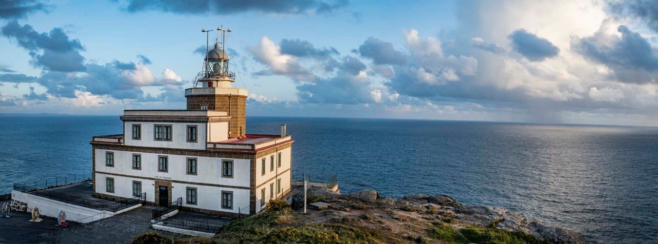 El faro del fin del mundo en Fisterra, donde el Sol hace su show cada atardecer ante un público entregado.