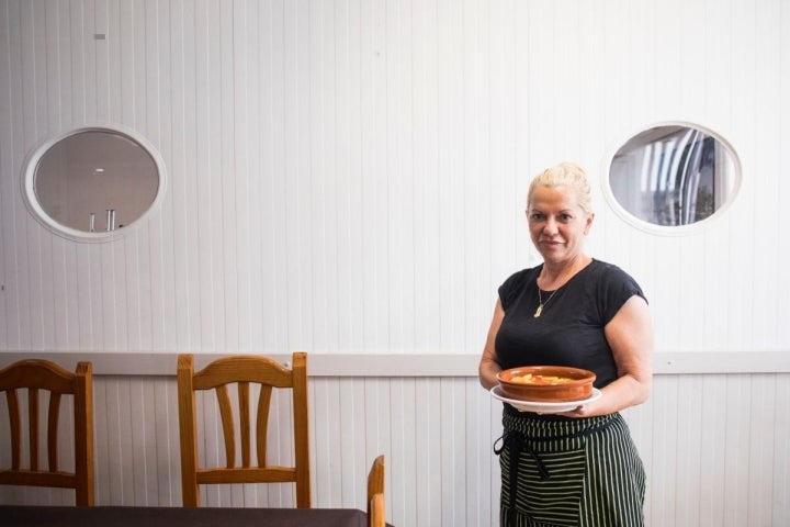 La cocinera de 'la Primitiva' con un plato de 'All i pebre'.