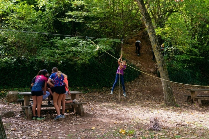 Niñas jugando en una tirolina en Parc El Molí Nou de Moià (comarca del Moianès, Barcelona).