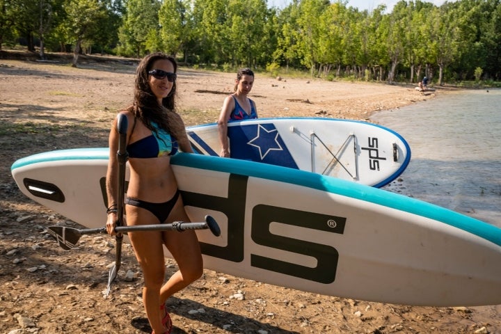 Dos chicas llevan sus tablas de SUP