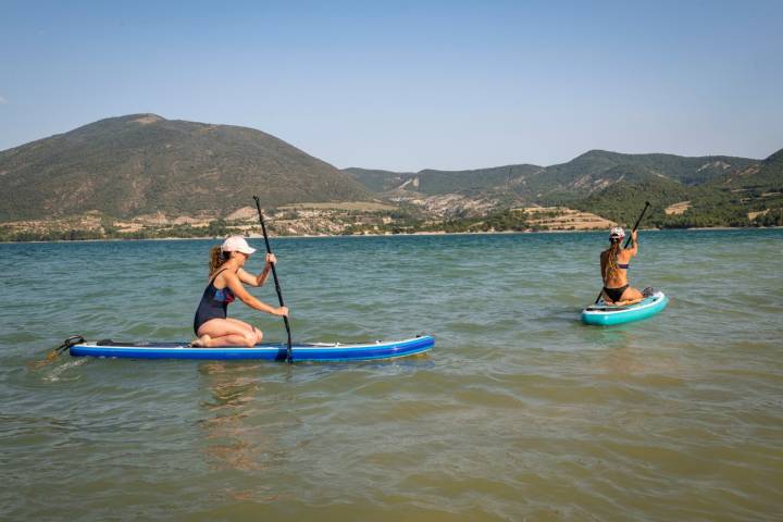 Dos chicas navegan con sus tablas de SUP