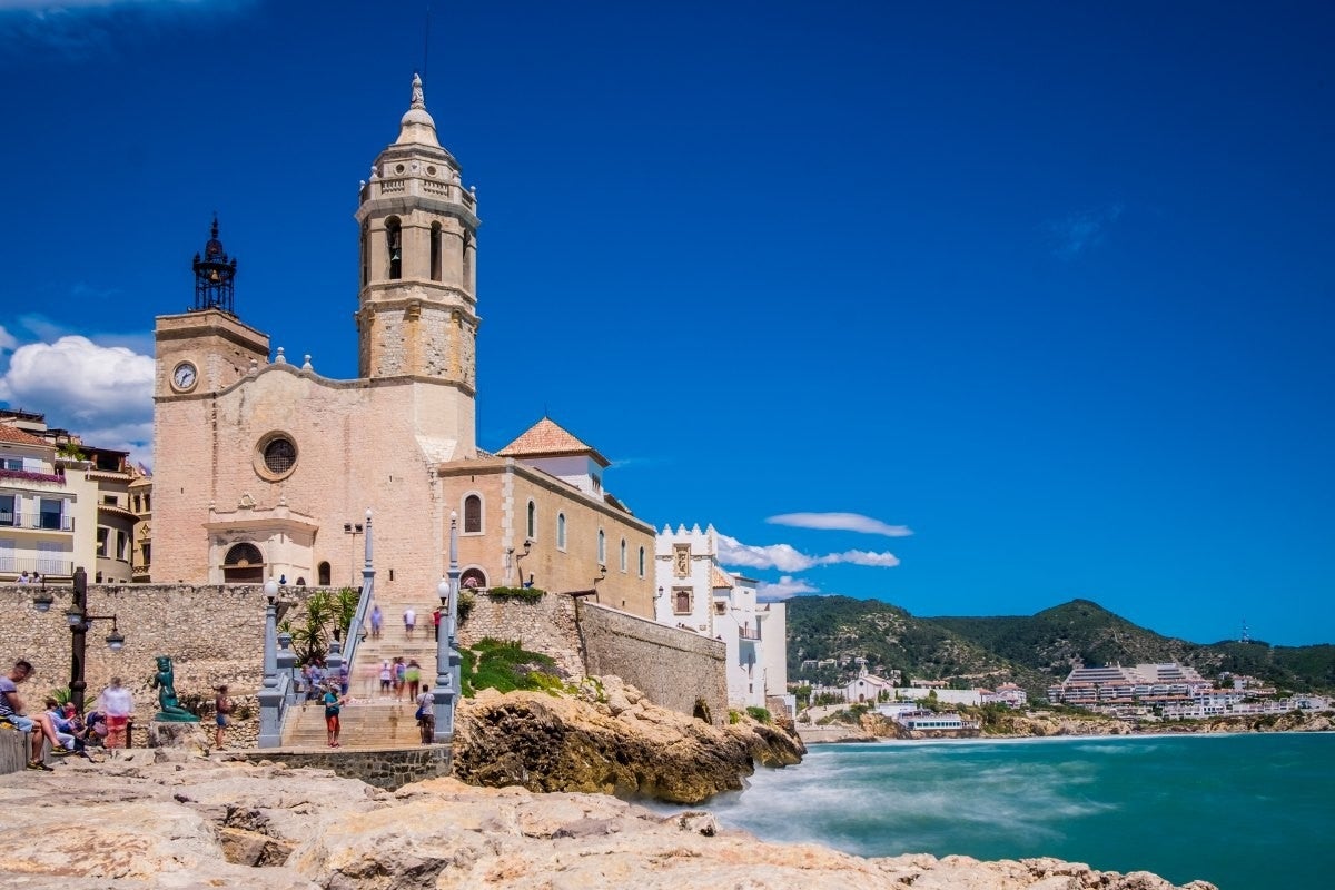 Una pareja descansa a la sombra mientras mira hacia el paseo marítimo de Sitges.