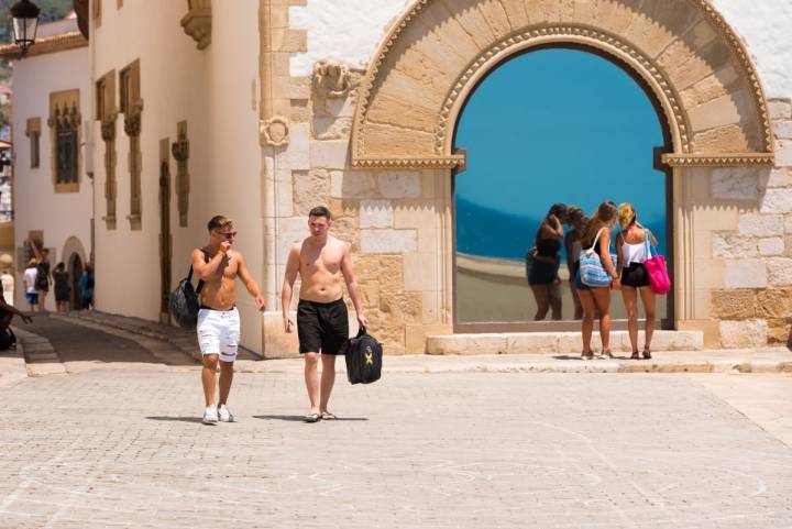 Unos turistas pasean por el centro histórico de Sitges, Barcelona. Foto: Shutterstock.
