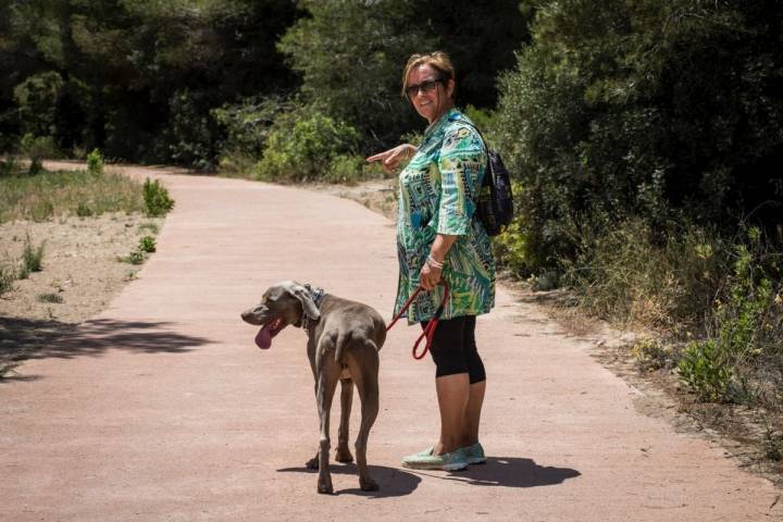 Una mujer pasea junto a su perro por la Dehesa de El Saler (Parque Natural de La Albufera, Valencia).
