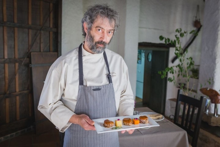 Luismi, del restaurante Arrieros, en Linares de la Sierra, con uno de sus platos a base de cerdo ibérico, en el Parque Natural Sierra de Aracena y Picos de Aroche, Huelva.