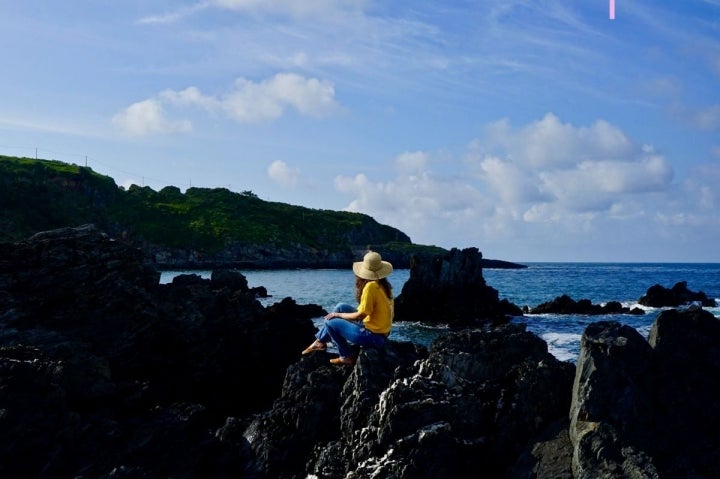 Una chica mira al mar en la playa de La Tercera, Luarca, Asturias.