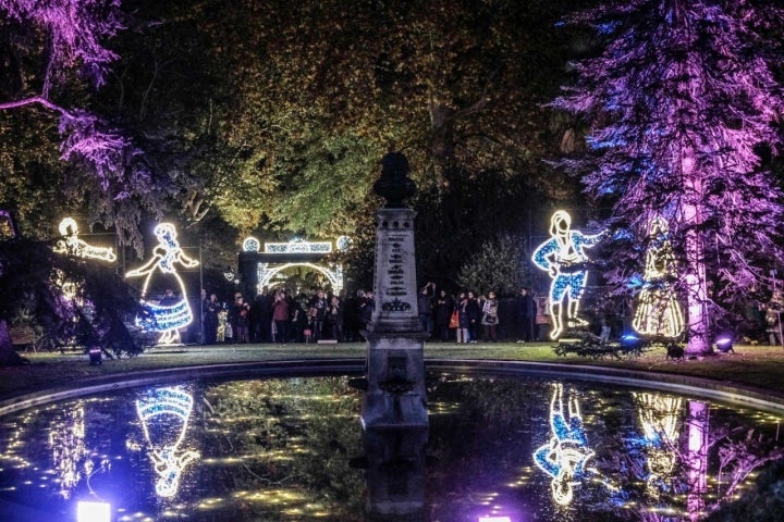 En la plaza de la Alegría con figuras tras las puertas iluminadas.