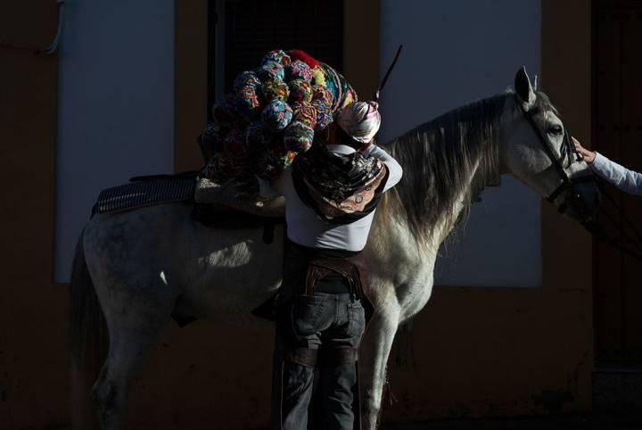 Un hombre preparando su caballo. Foto: Manuel Ruiz Toribio.