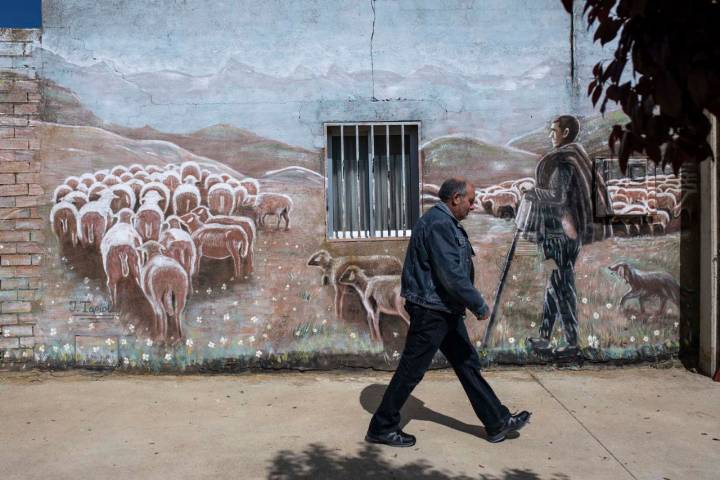 Joaquín paseando ante un mural de un pastor con sus ovejas.