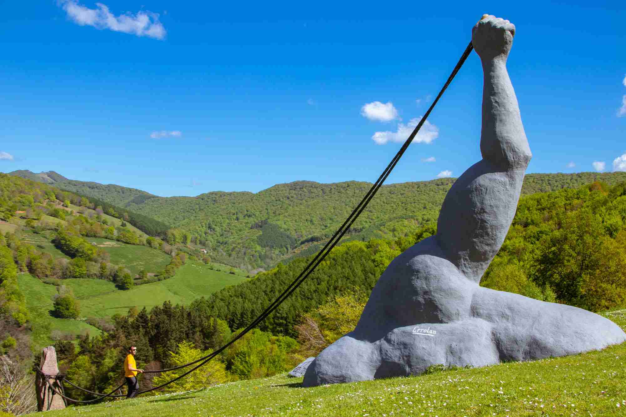 Gigante escultura de un brazo tirando de una cuerda.