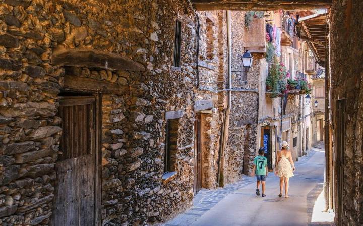 Una mujer y un niño caminan por una de las calles estrechas de Robledillo de Gata, uno de los pueblos más bonitos de España.