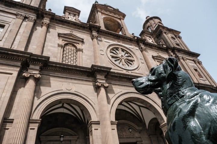 Escultura de un perro y fachada de la catedral de Santa Ana.