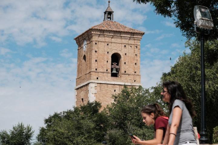 Dos personas contemplan Chinchón con la Torre del Reloj al fondo.