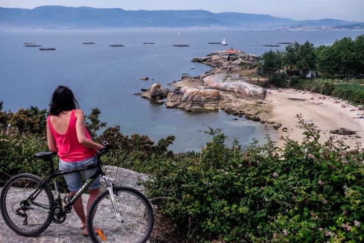 En cualquier alto del camino, las playas y el faro se perfilan sobre la ría repleta de bateas.